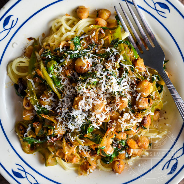 Chickpea and Gai Lan Spaghettini in a blue and white bowl with a fork