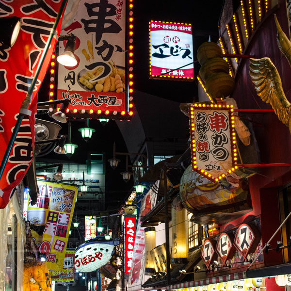 A street scene in Osaka, Japan, showing various colourful restaurant signs