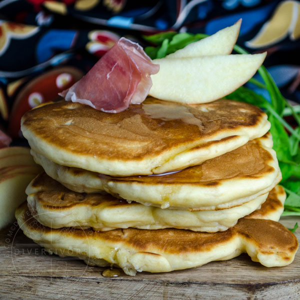 Prosciutto, apple, and arugula pancakes on a wooden board