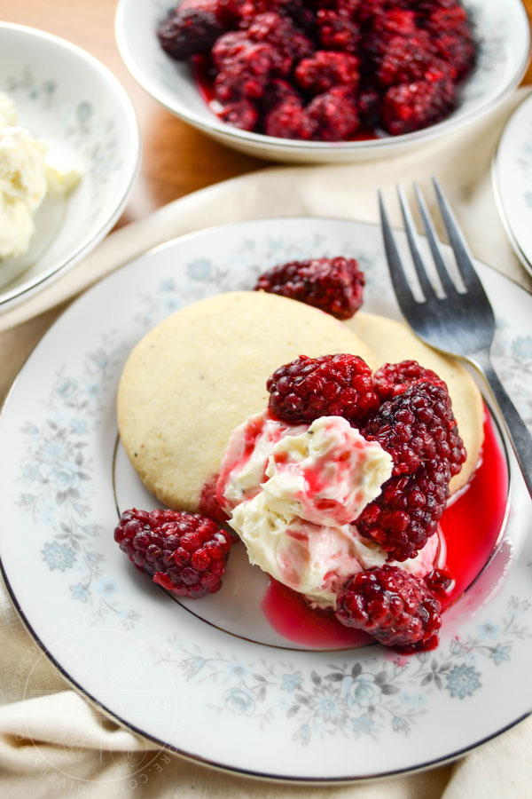 Pepper shortbread cookies with tayberries and sweet cream cheese on a small floral patterned plate